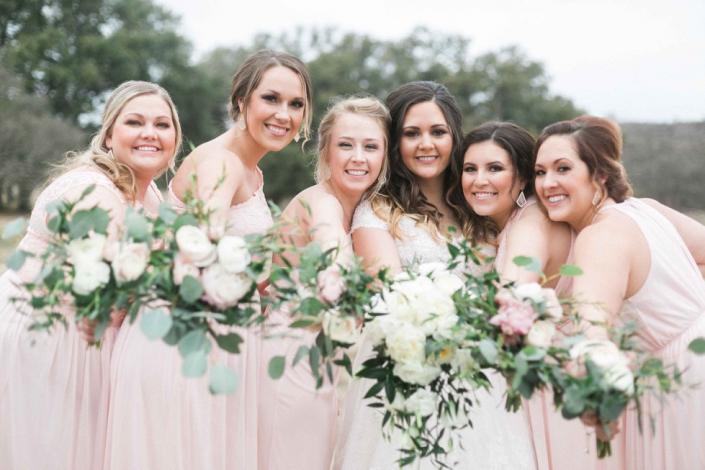 Bridesmaids with the bride displaying elegant florals. 