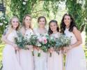 A stunning wedding party of bridesmaids in soft pink dresses with elegant floral bouquets. 